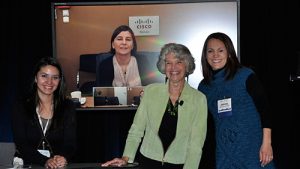 Image of four people facing the camera and smiling