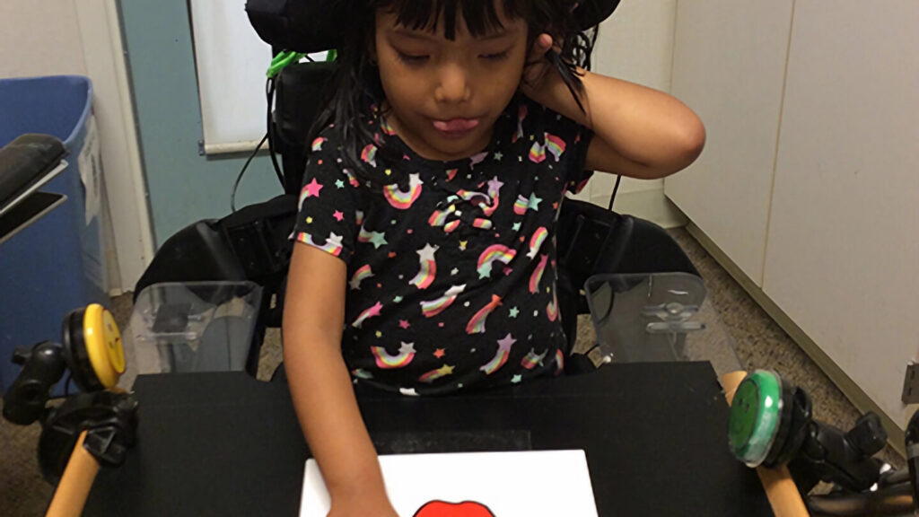 Image of a child interacting with a tablet on a table in front of them