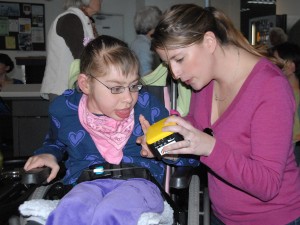 Annie and her friend, Lindsey program the communication device to cheer on her teammates.