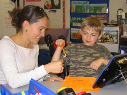 Gaby works with a student on a writing activity.